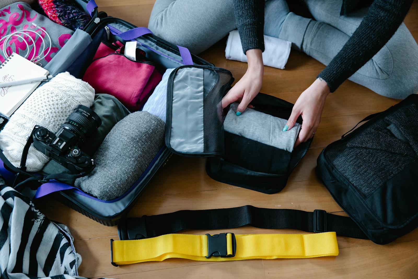 Person using packing cubes to organize luggage