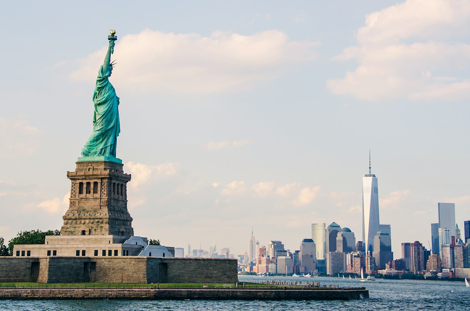 The statue of liberty is in the middle of the water