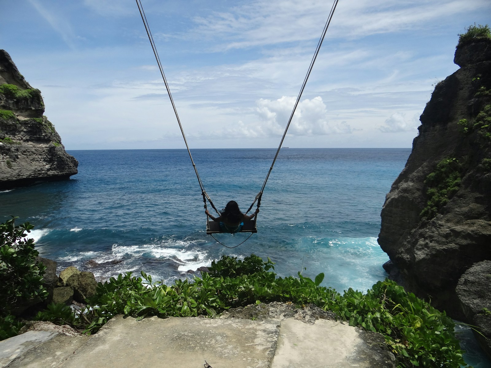 Bali, Indonesia A person in a hammock suspended over the ocean