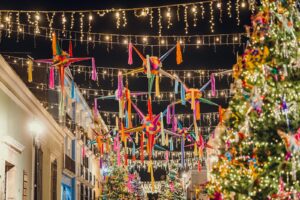 Vibrant Christmas decorations with piñatas and lights in the festive streets of Oaxaca at night.