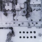 aerial photography of snow capped field near buildings