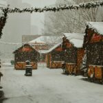 a snowy street lined with wooden buildings