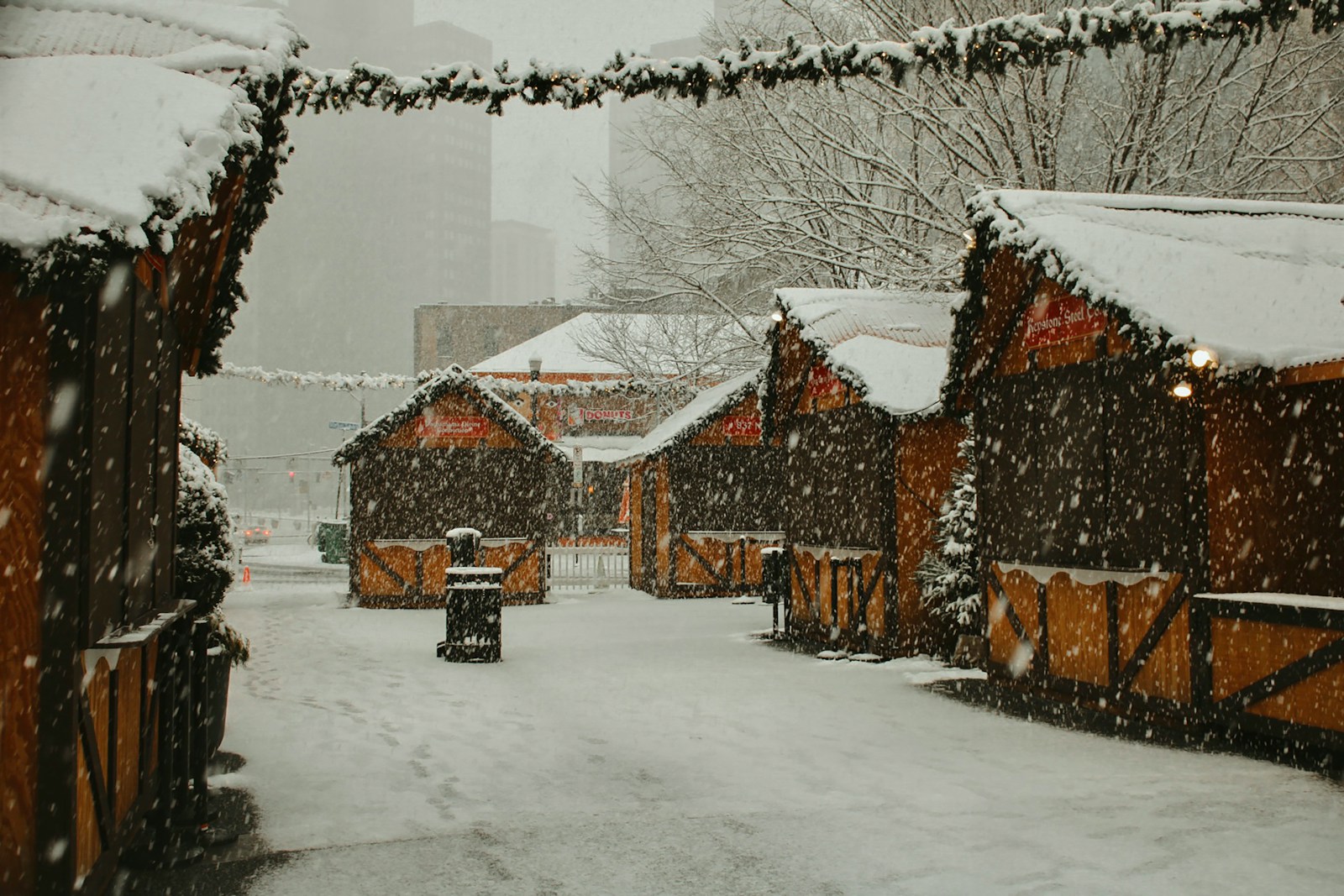 a snowy street lined with wooden buildings